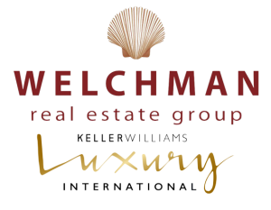 Logo for Renee Welchman Real Estate Group. At top center is a peach-colored scallop shell. Below, it reads, "WELCHMAN // real estate group // KELLER WILLIAMS // Luxury // INTERNATIONAL".
